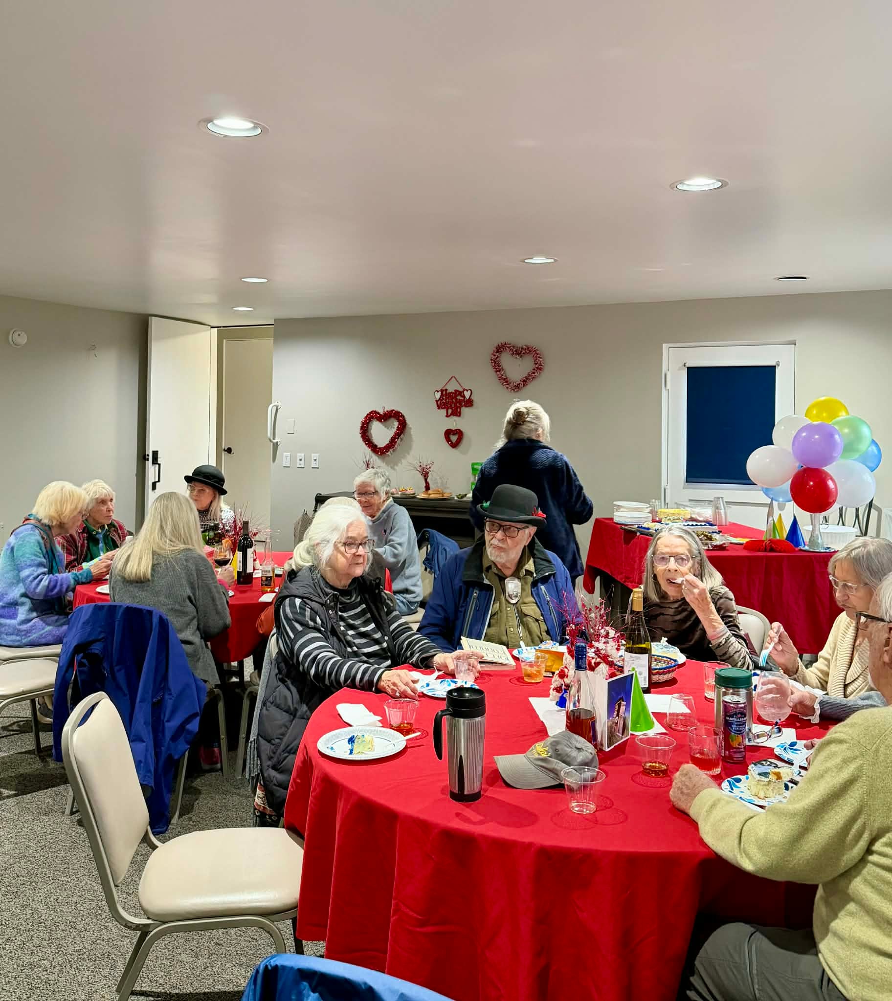 Residents enjoying a Valentine's Day community gathering with decorated tables